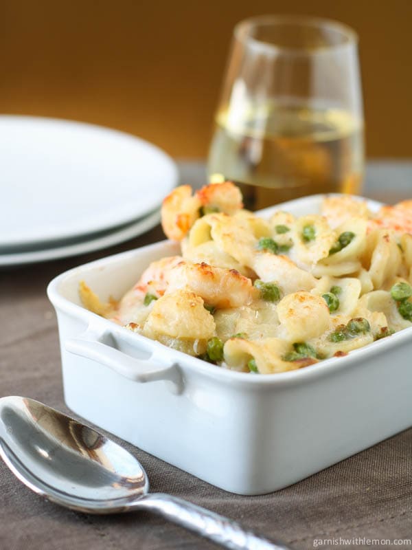 Shrimp Pasta with Peas in white dish.