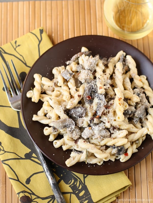 Pasta with Sausage, Mushrooms and White Wine Cream Sauce on plate with red pepper.