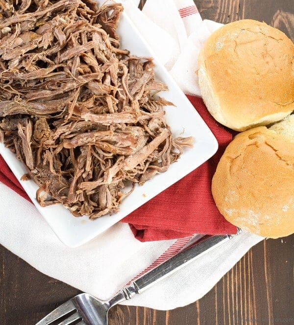 pulled beef on white tray with buns. 