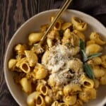 A bowl of pumpkin pasta with sage garnish.