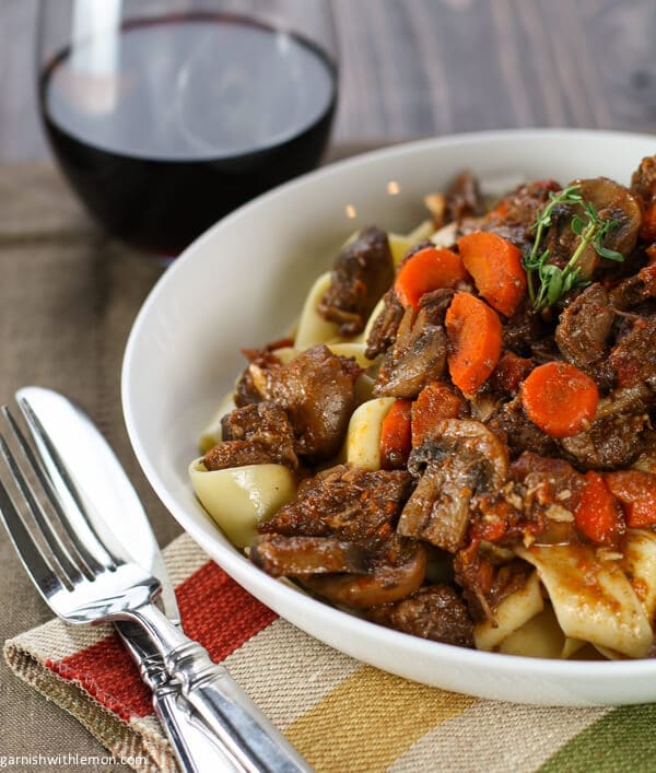 Beef Provencal in white bowl with carrots and thyme.