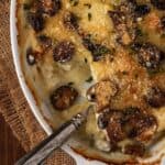 Mushroom & Potato Gratin in white dish with a serving spoon.
