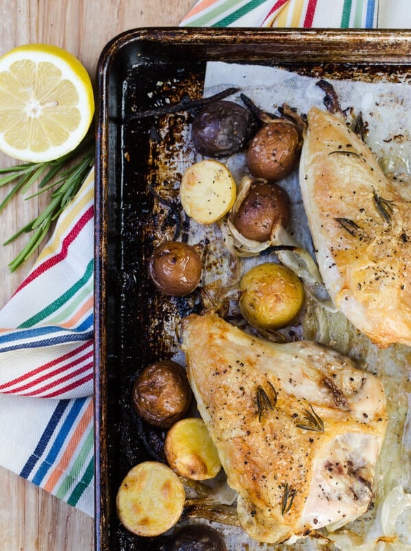 A sheet pan filled with potatoes and chicken breasts.