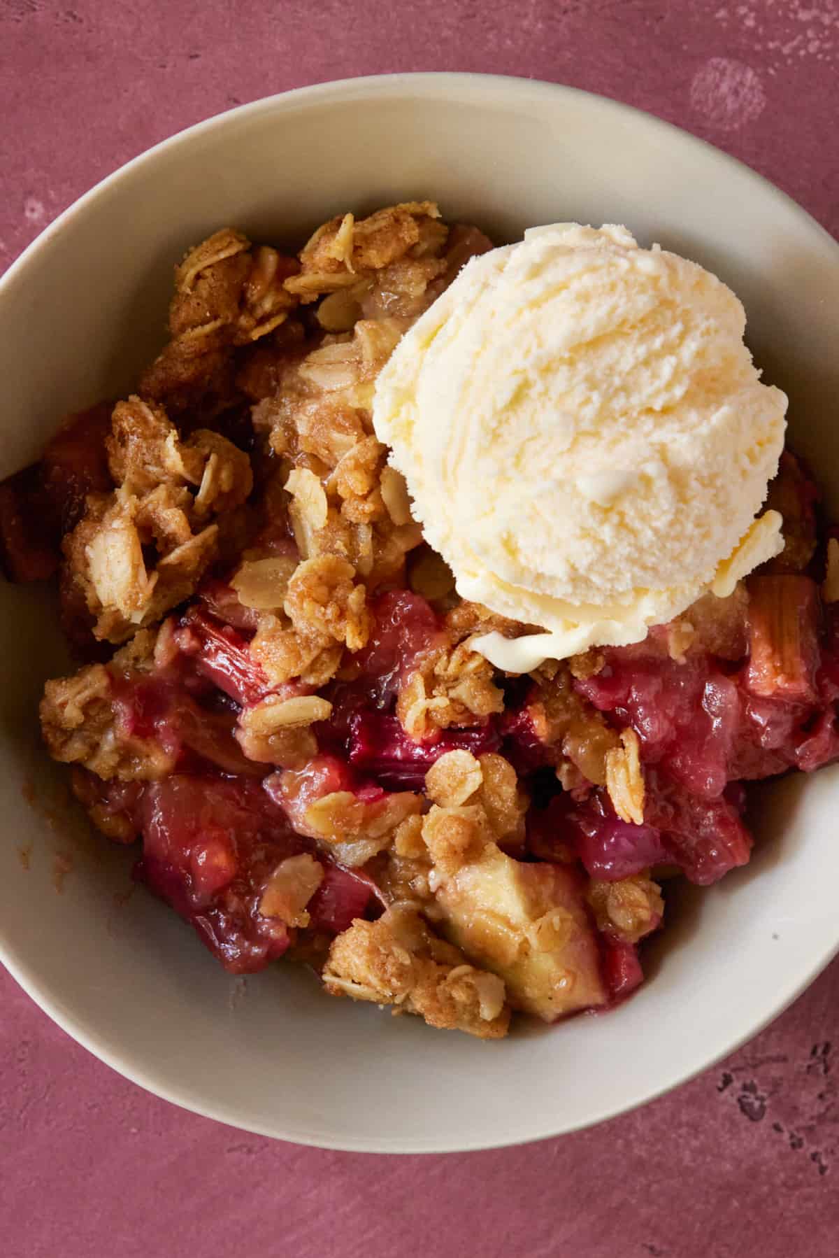 Bowl of fruit crisp with ice cream.