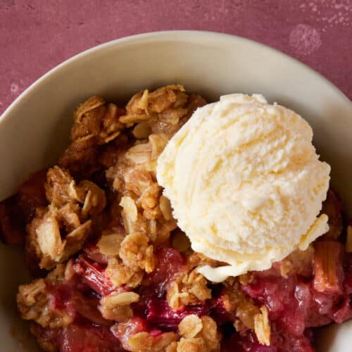 bowl filled with fruit crisp and vanilla ice cream.