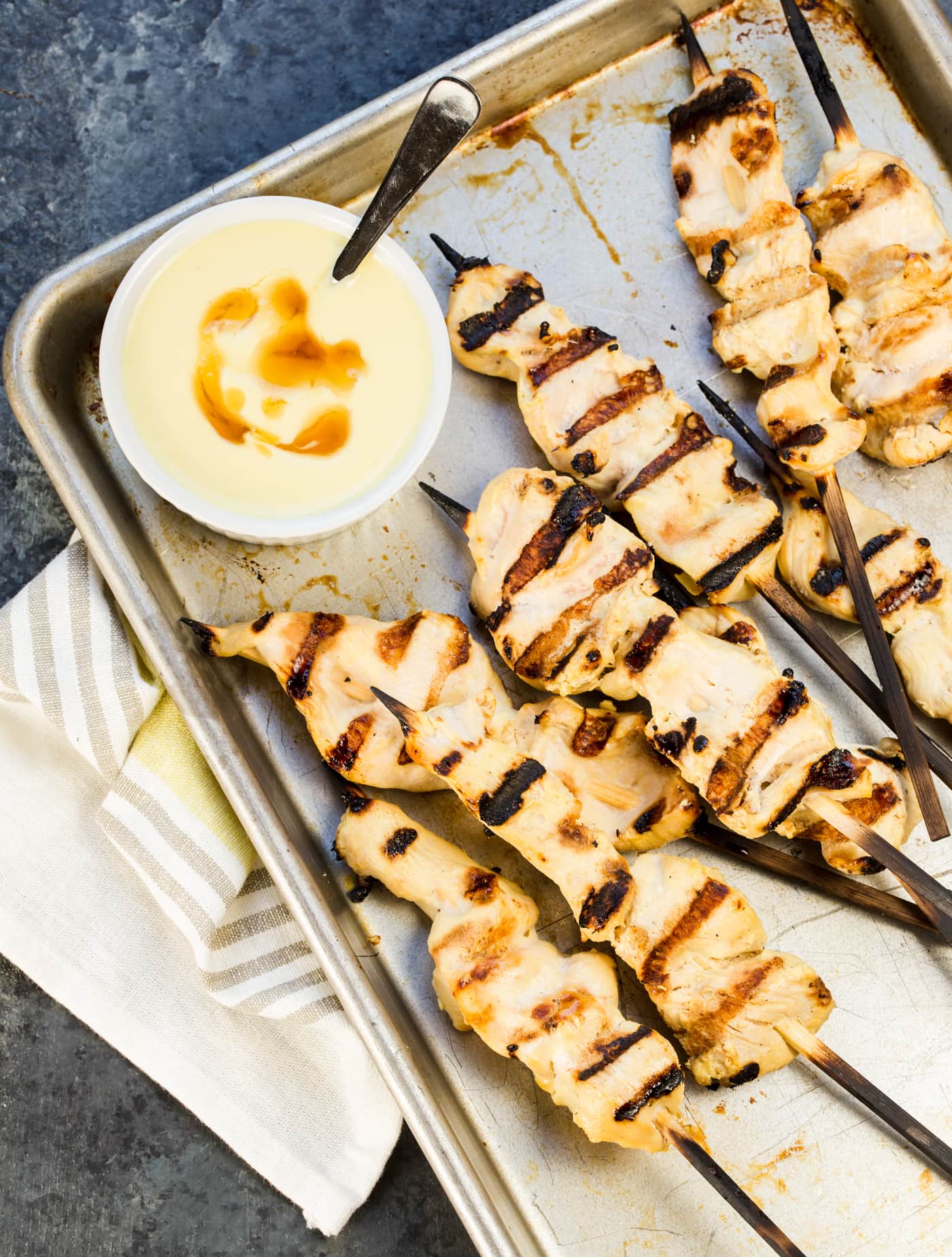 Grilled chicken skewers on sheet pan with honey mustard dipping sauce.