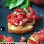 crostini on plate with tomatoes.
