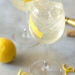 tall stemmed wine glasses filled with white wine and ice.