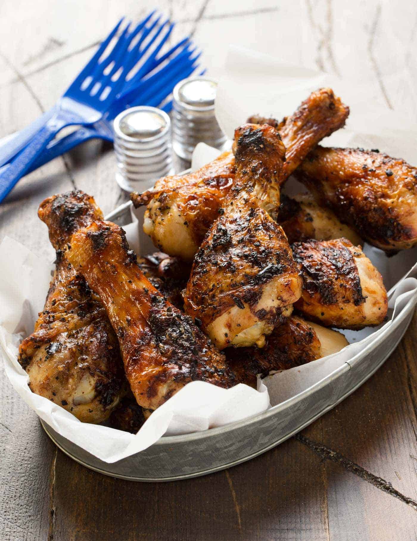 A silver tray filled with grilled chicken legs.