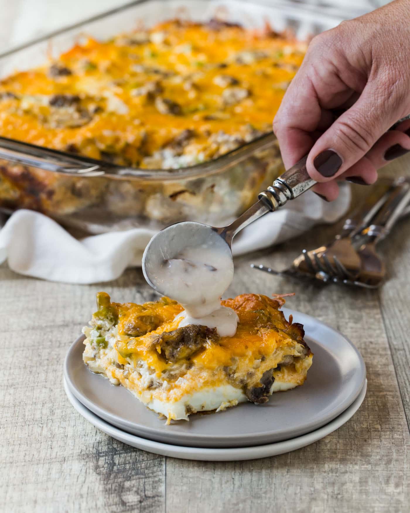 A plate of food with a fork and knife, with Casserole and Cheese.