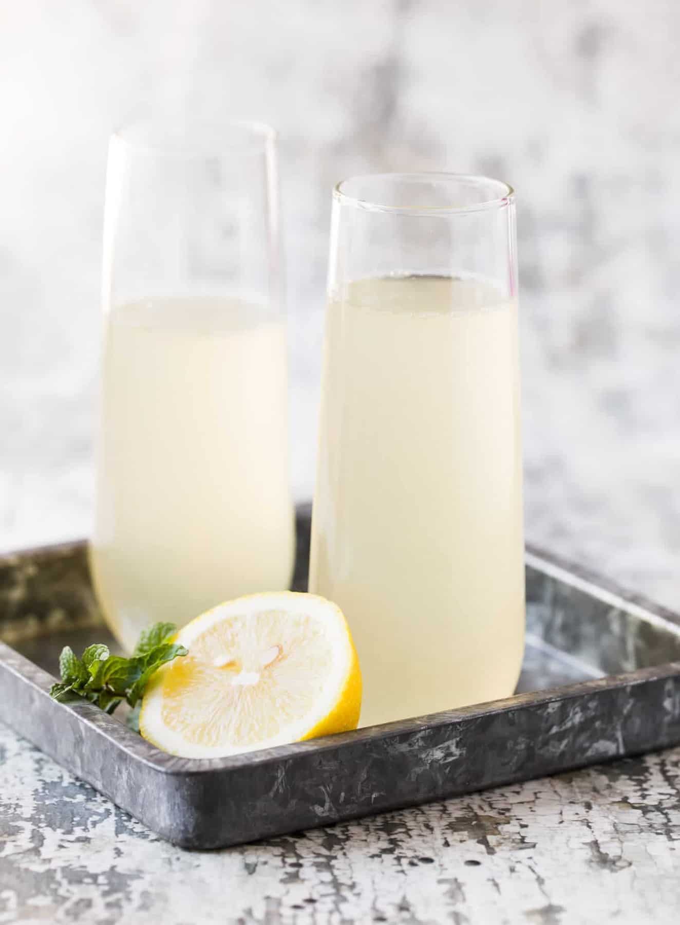 Glasses of lemon and prosecco in a tray.