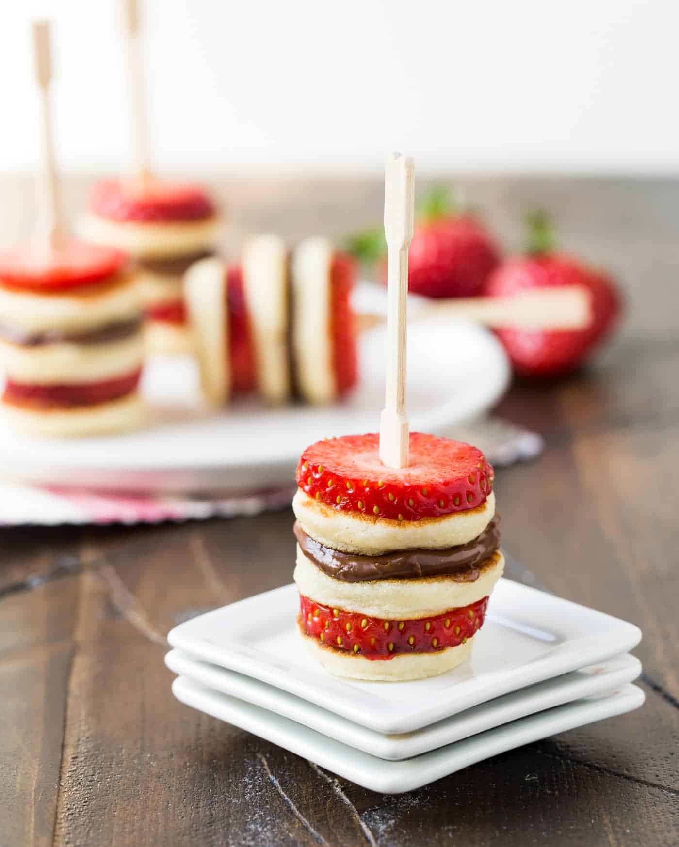 Mini pancakes and strawberries on skewer.