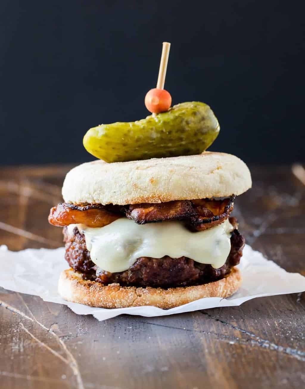  Burger with Irish Cheddar and Bacon on a toasted English muffin and topped with a mini gherkin pickle. 