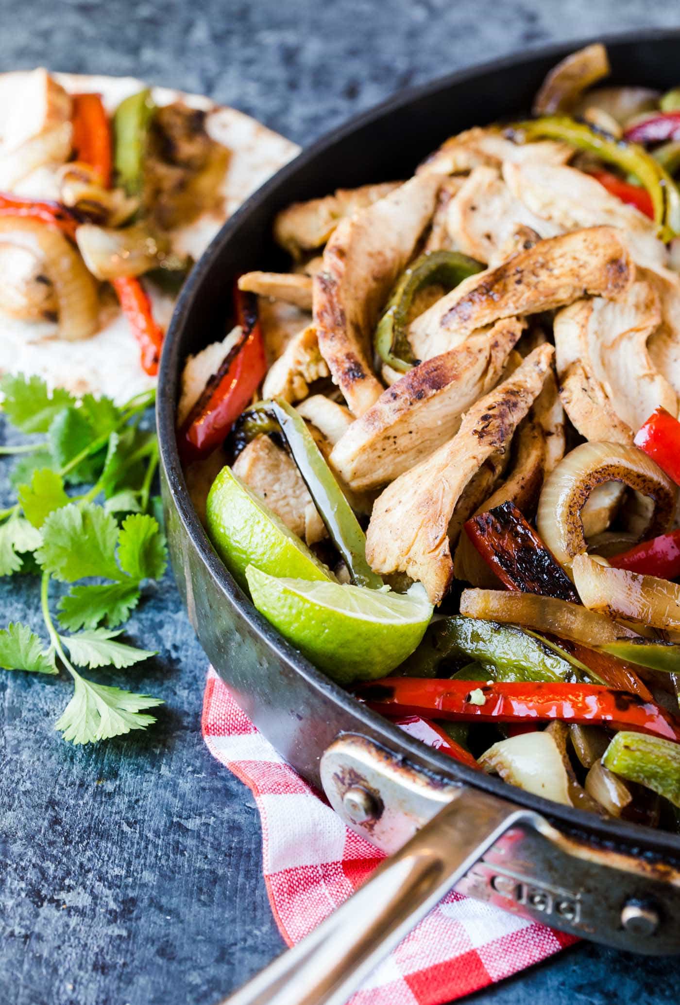 A close up of chicken fajitas in grill pan.