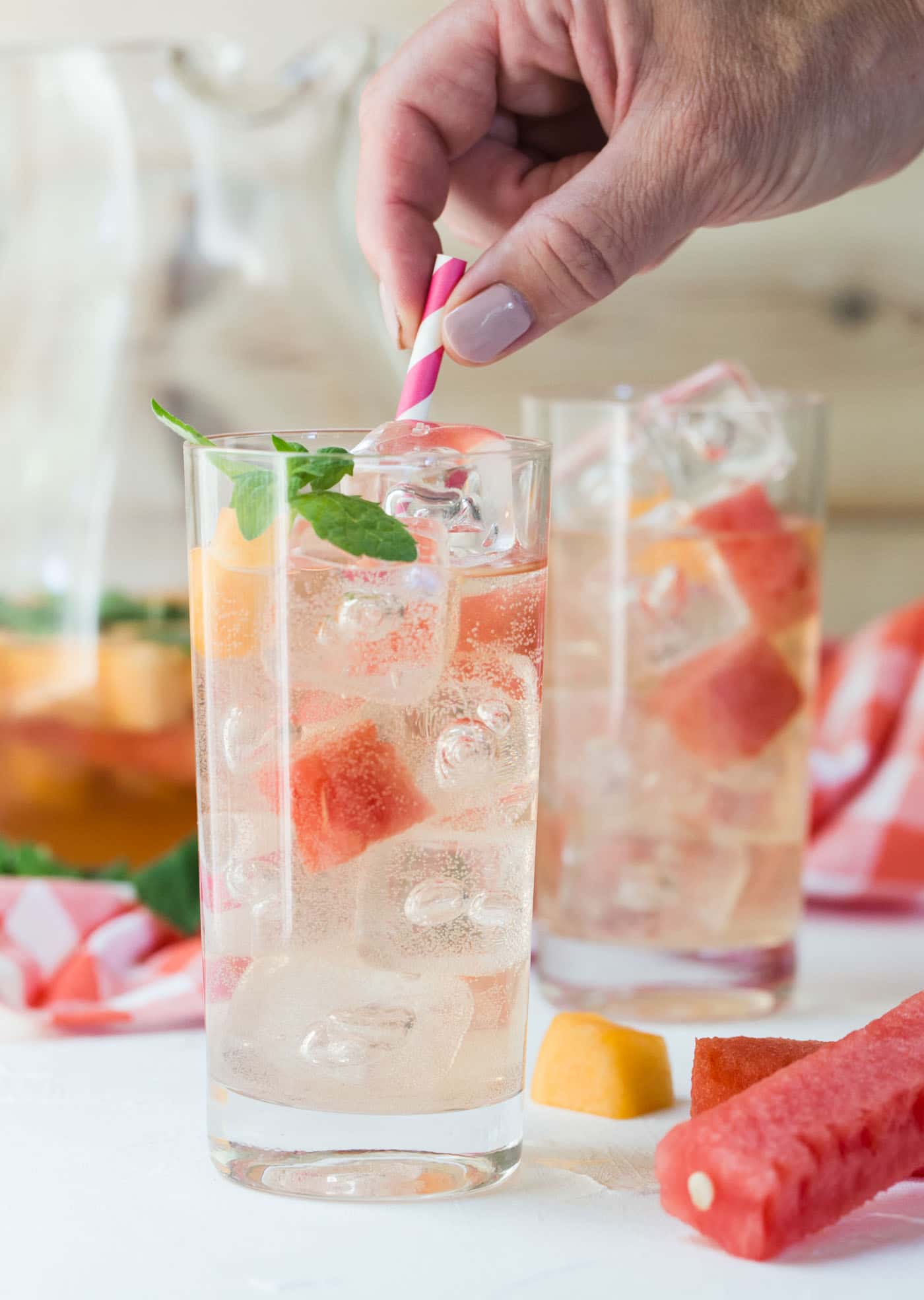 Rosé Elderflower Sangria over ice served with melon balls and mint leaves.