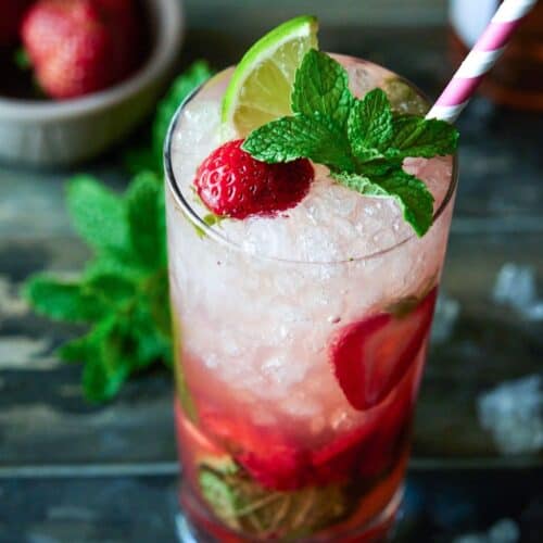 high ball glass filled with ice, strawberries and drink.