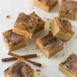 Snickerdoodle Bars cut into squares with cinnamon sticks on side.