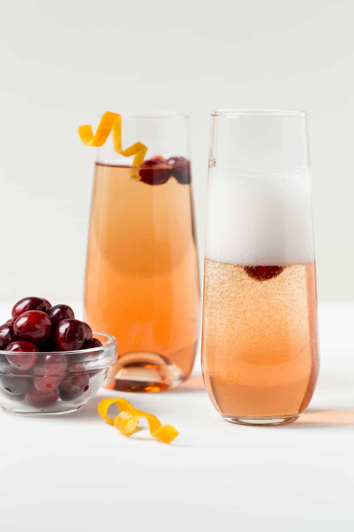 A glass of orange juice, with Cranberry and Prosecco.