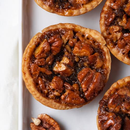 Mini Pecan Pies on white tray.