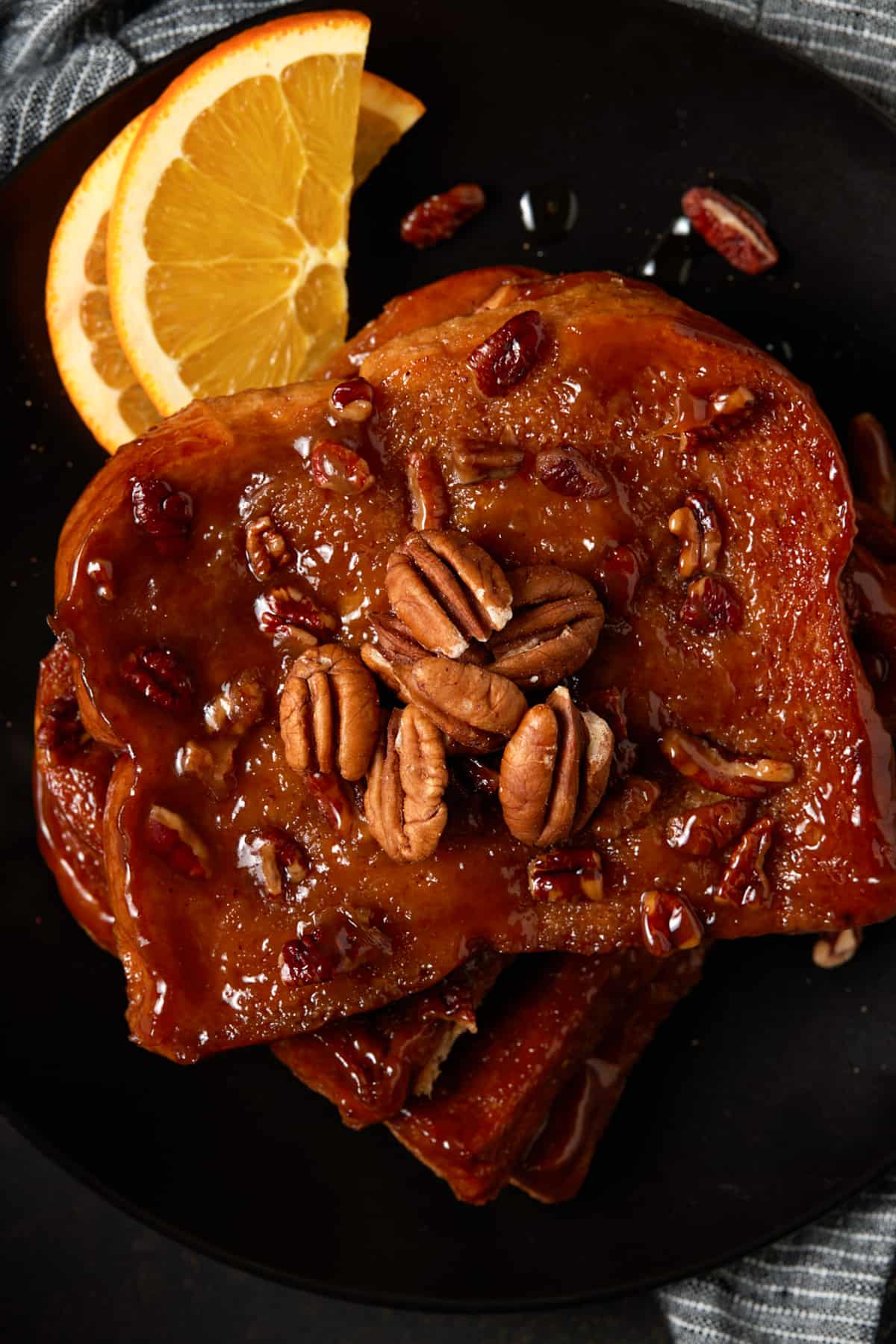 Pieces of brioche french toast on a black plate. 