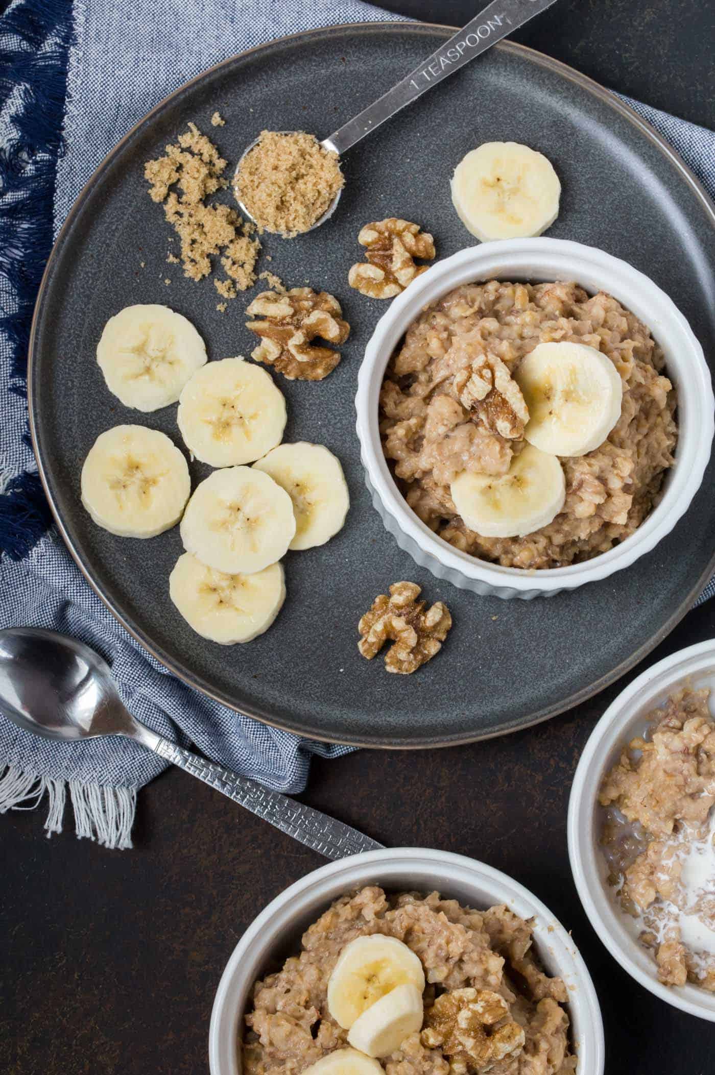 Ramekins filled with oatmeal, banana slices and walnuts. 