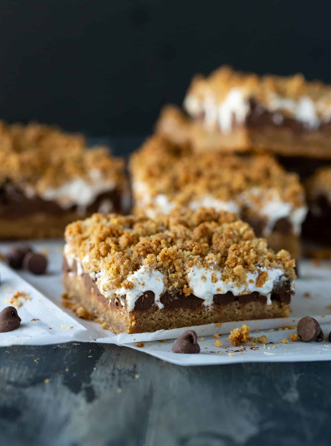 Pile of easy Gooey Baked S'mores Bars on parchment paper.