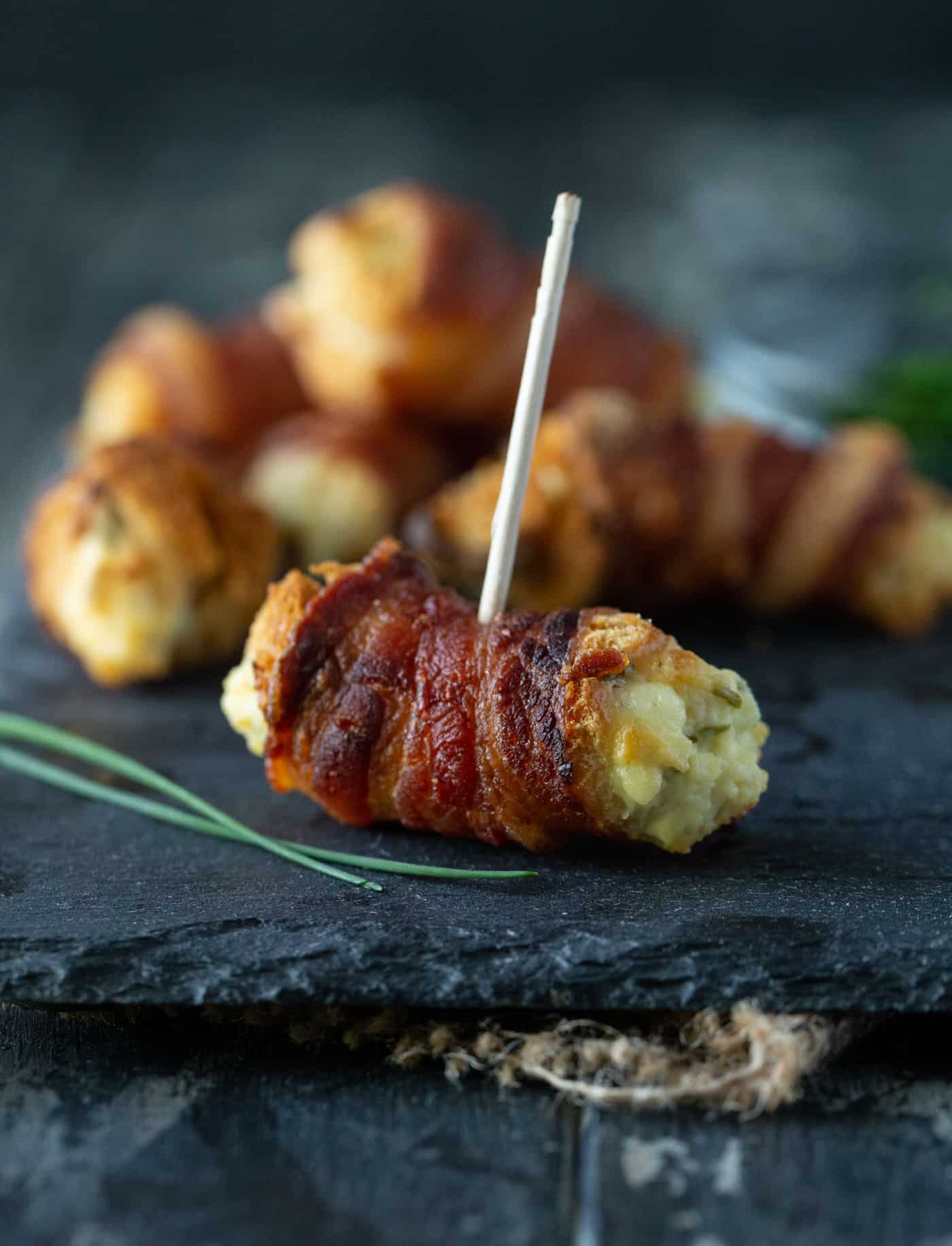Close up shot of cooked bites on dark background with toothpick.