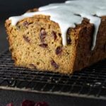 Loaf of Cranberry Zucchini Bread on a cooling rack with a drizzle of vanilla bean glaze.