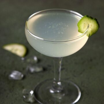 Cucumber vodka gimlet in a glass with a cucumber garnish.