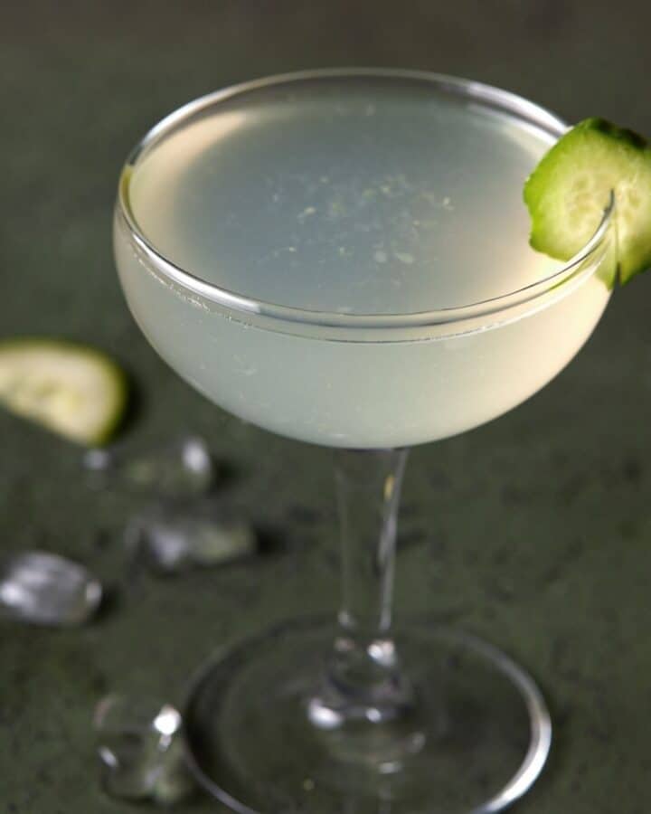 Cucumber vodka gimlet in a glass with a cucumber garnish.