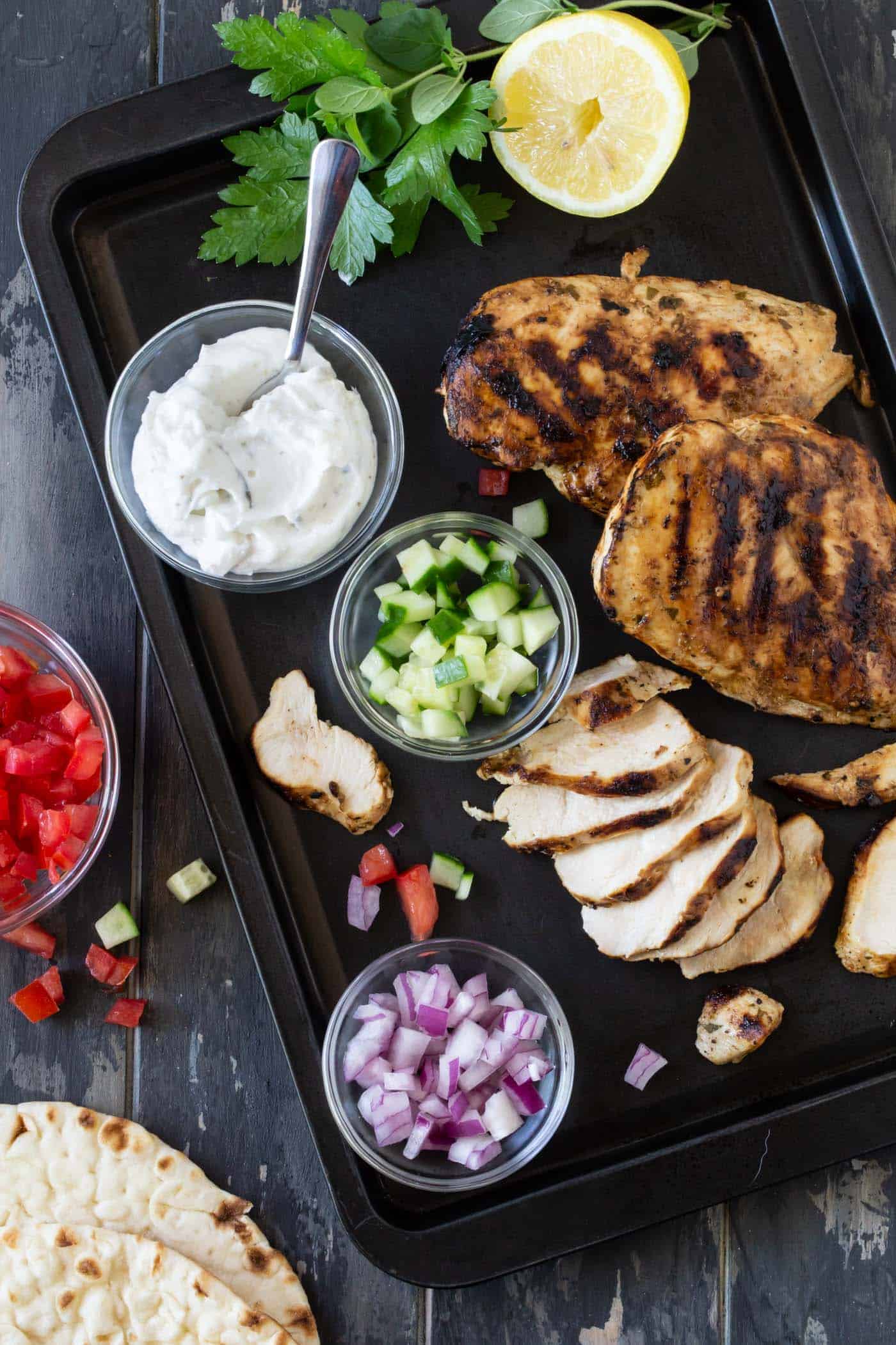 chicken gyros with sliced onions, chopped cucumber and chopped tomatoes for assembly.