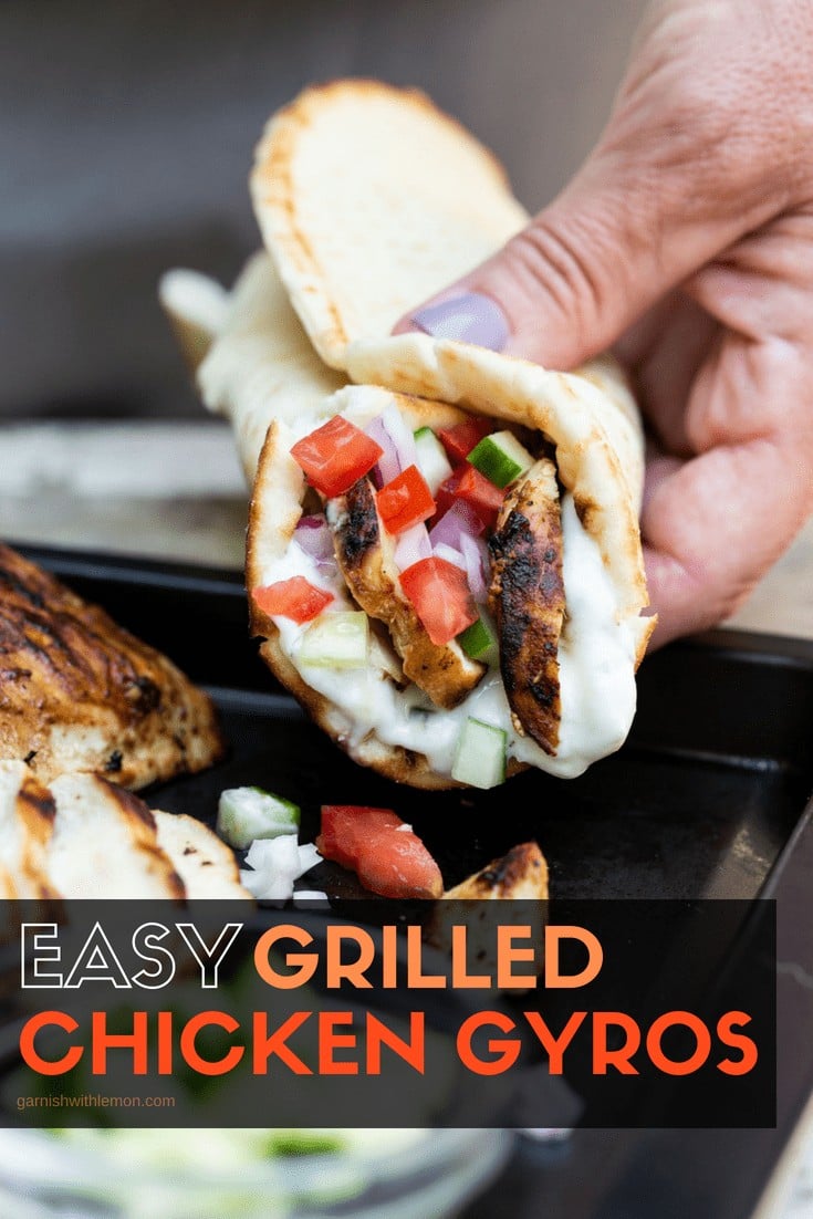 chicken gyros with flatbread holding grilled chicken, tzatziki sauce, chopped tomato and chopped cucumber.