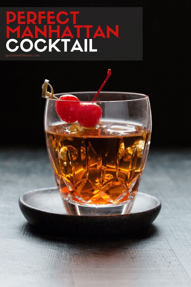 A glass cup on a table, with Manhattan and Vermouth.