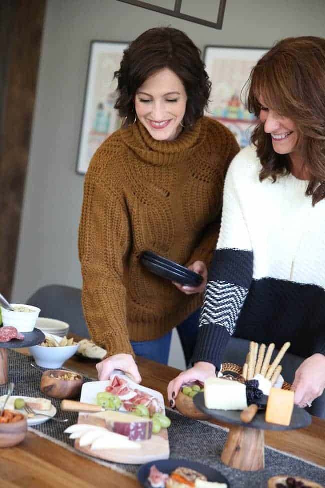 Lisa and Anna standing at a table with plates of food.