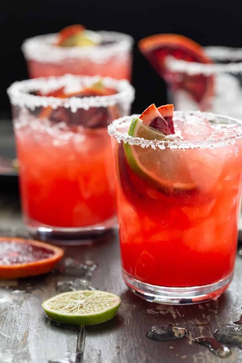 Glasses filled with Blood Orange Margaritas and garnished with fresh lime and blood orange slices.