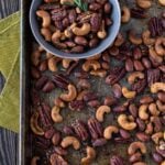 Nuts on a sheet pan with a small bowl filled with nuts.