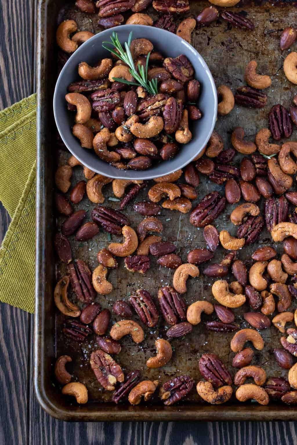  Nuts on a sheet pan with a small bowl filled with nuts. 