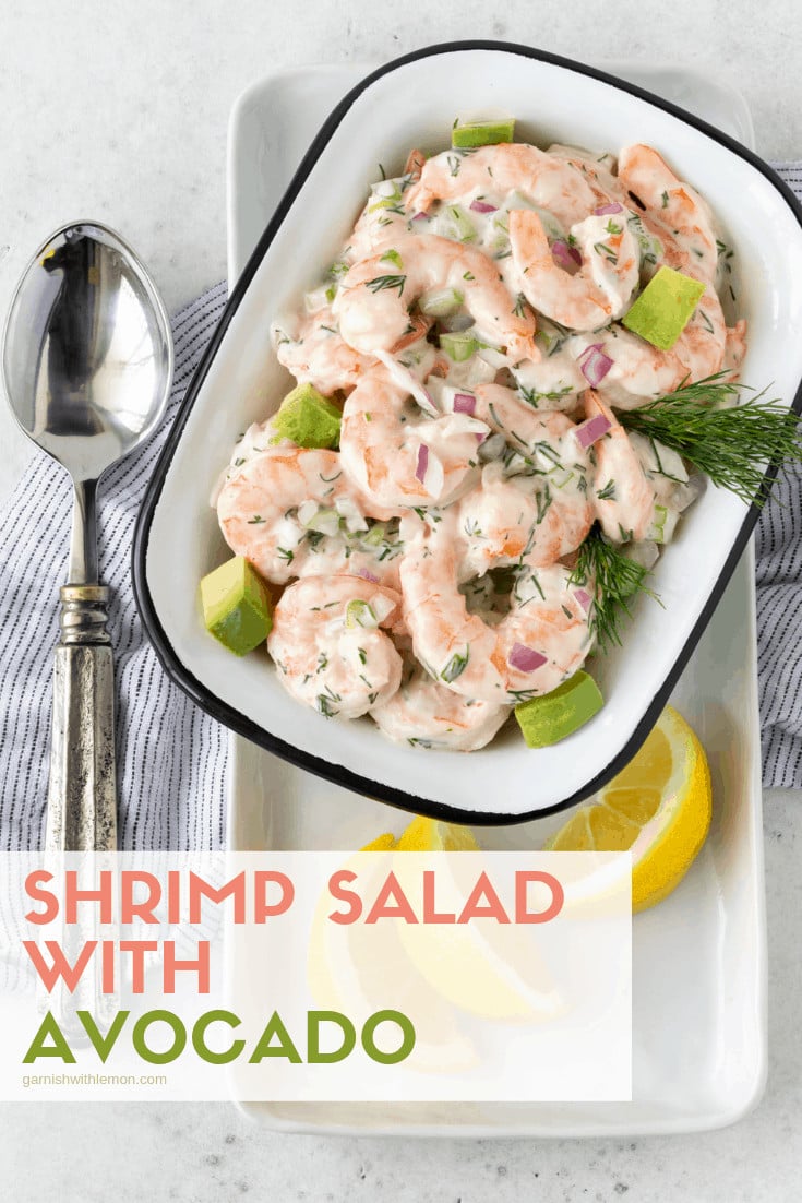 Shrimp Salad with Avocado in a white serving bowl garnished with fresh dill and lemon wedges.