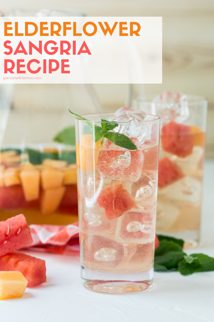 Edlerflower Sangria recipe in a high ball glass garnished with fresh mint, watermelon and canteloupe.