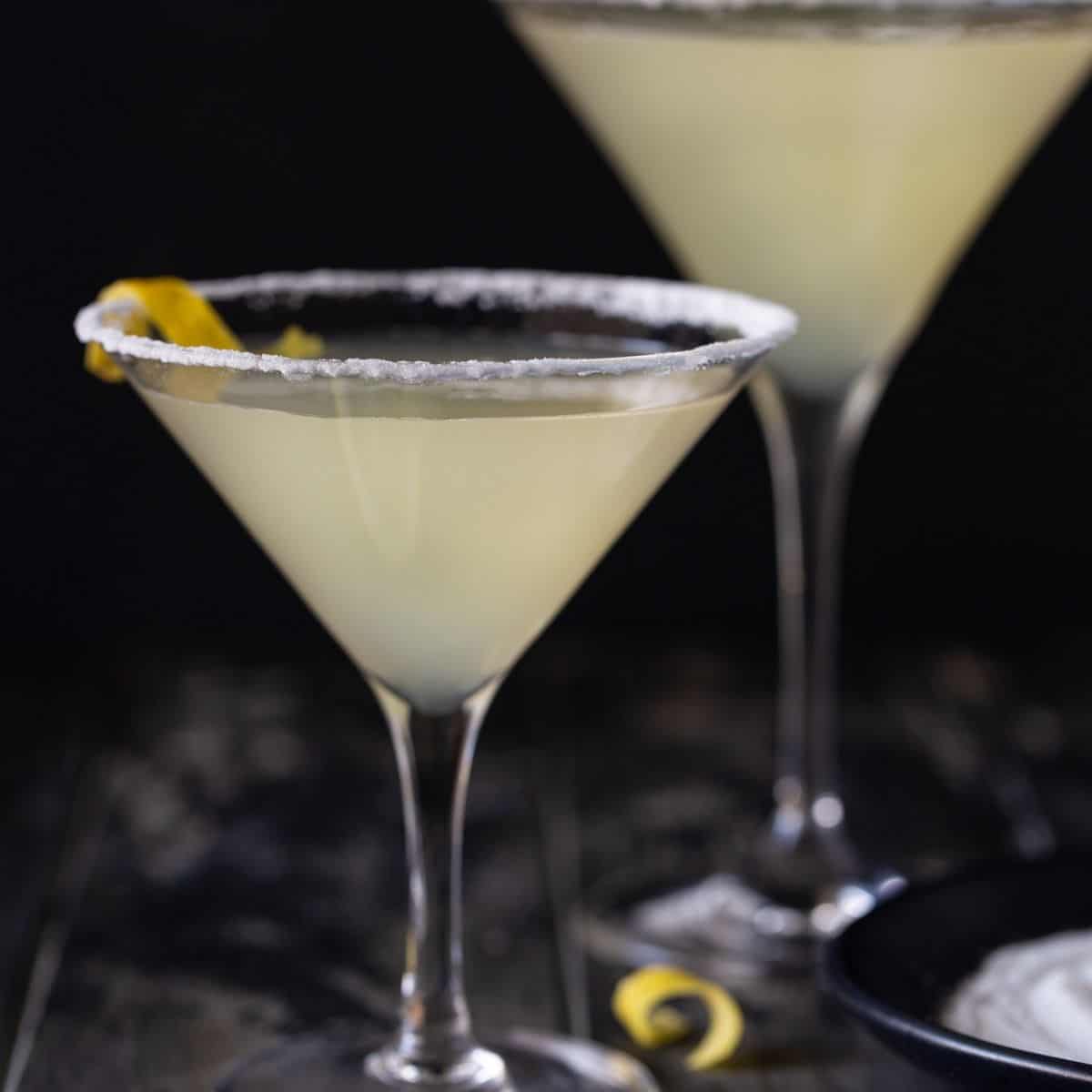 martini glasses on table with lemon peels.