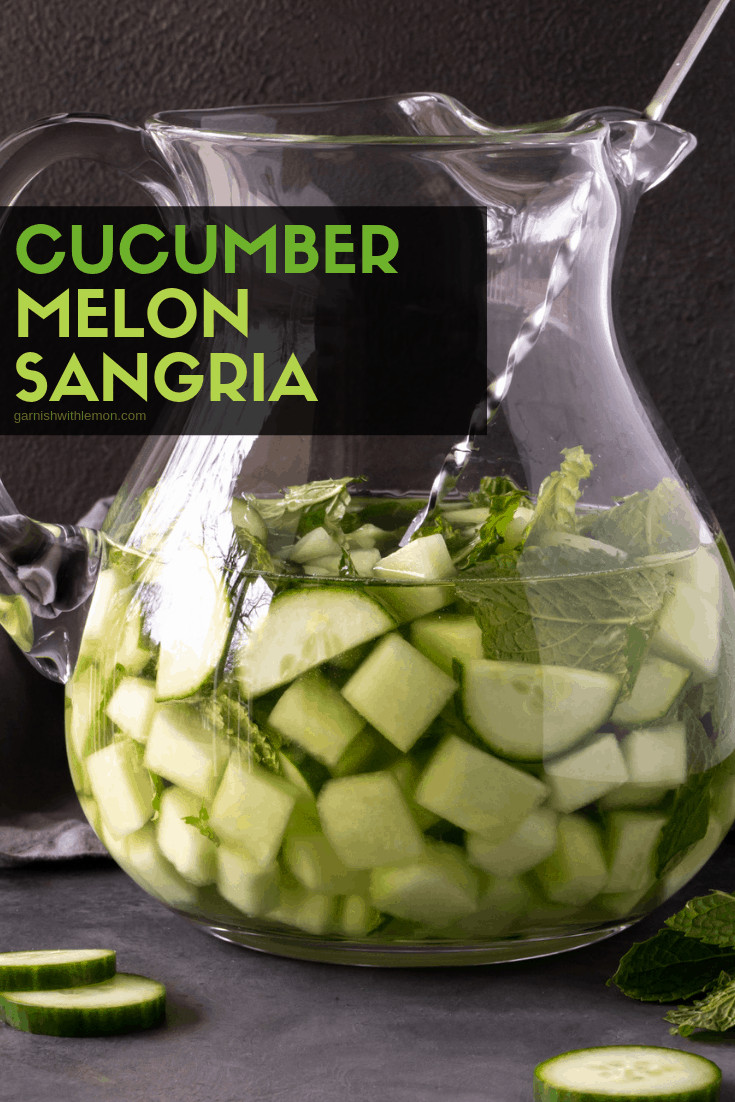 Large glass pitcher filled with Cucumber Melon Sangria.