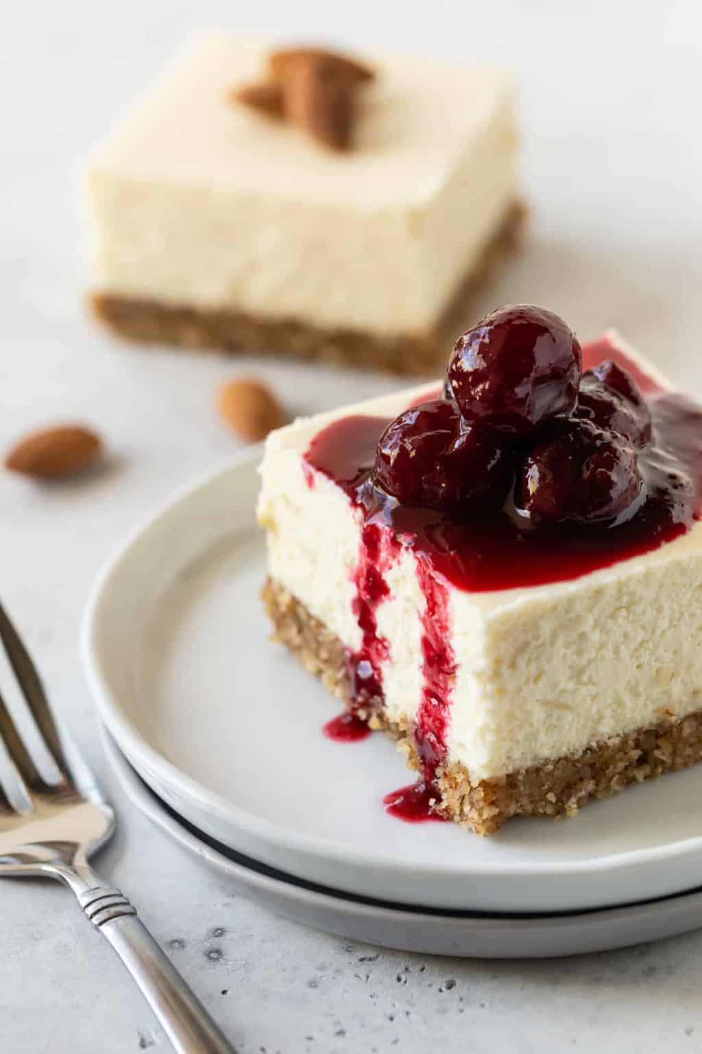  Cheesecake Bar slice on a small white plate with a fork.