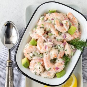 Shrimp Salad and avocado in a white bowl with black rim.