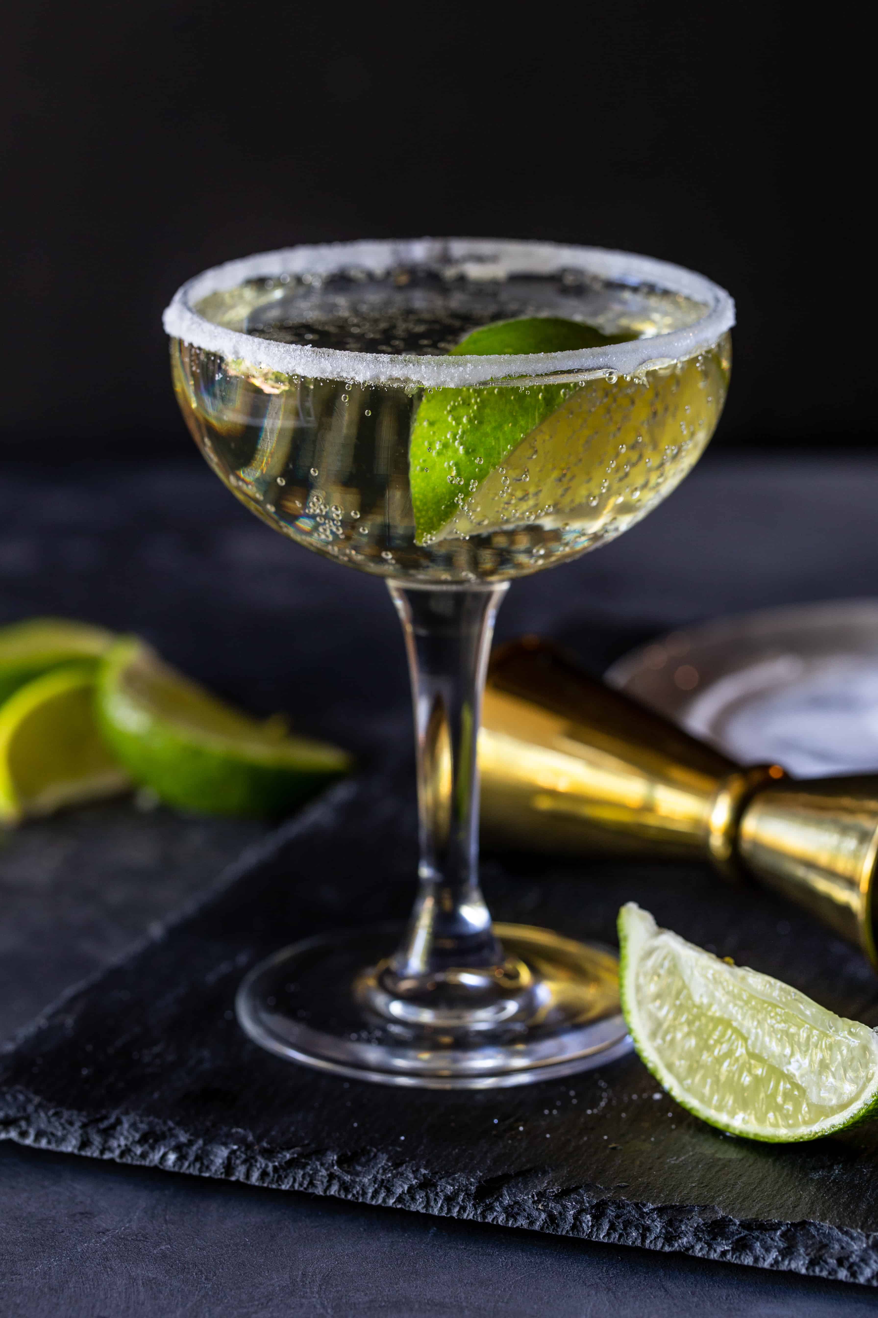 Gin Cocktail in a sugar rimmed glass with a fresh lime wedge.