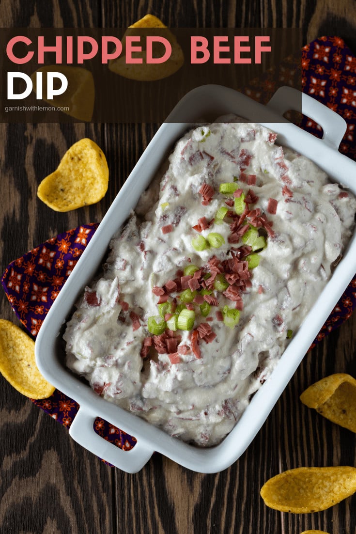 A dish filled with Chipped beef with chopped beef and onions for garnish.
