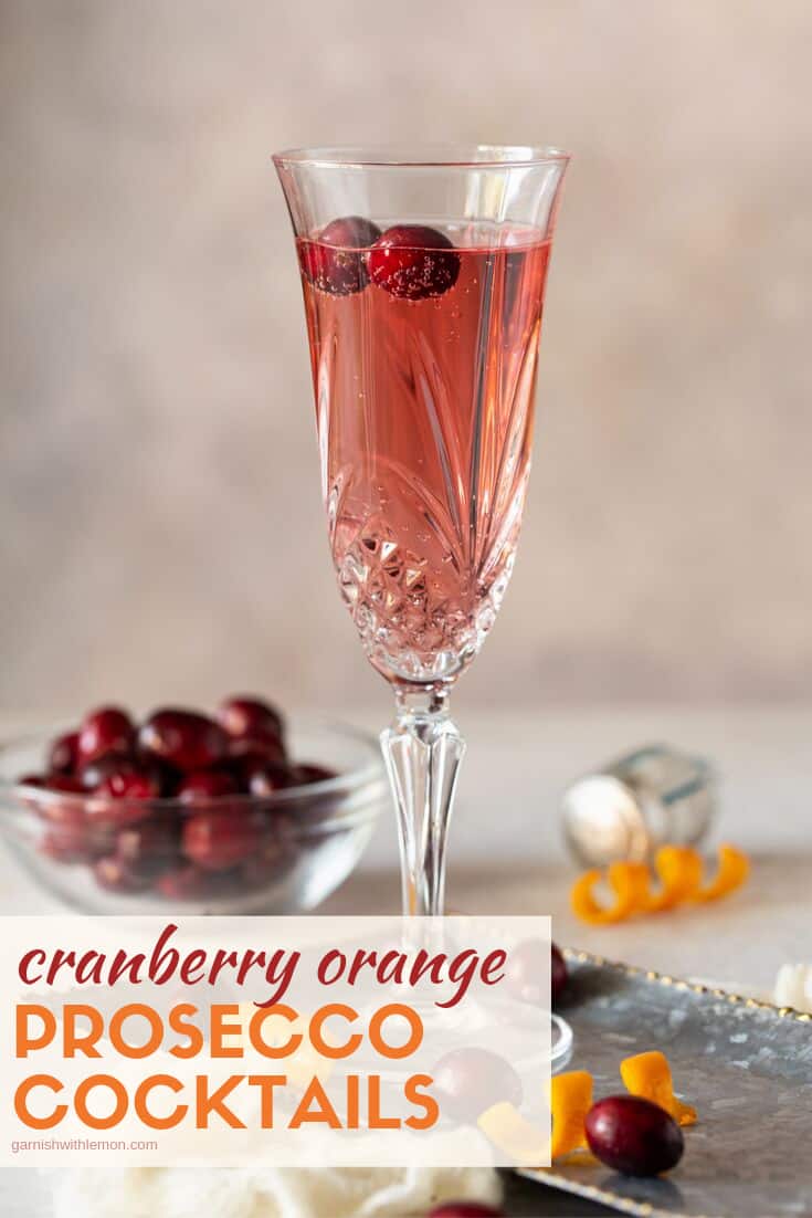 champagne flute with fresh cranberries and an orange twist for a garnish.