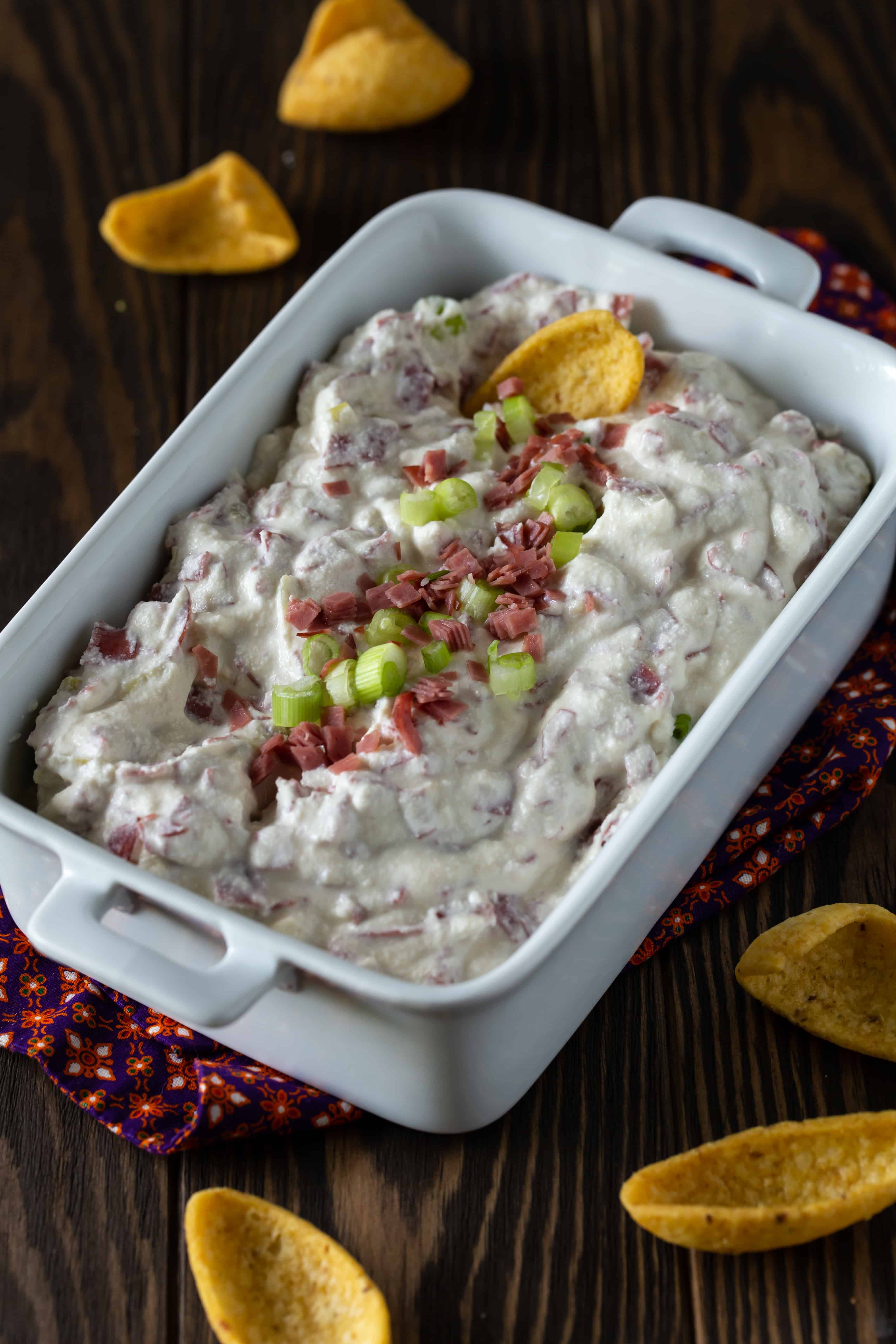 dip in a white baking dish with fritos for eating.