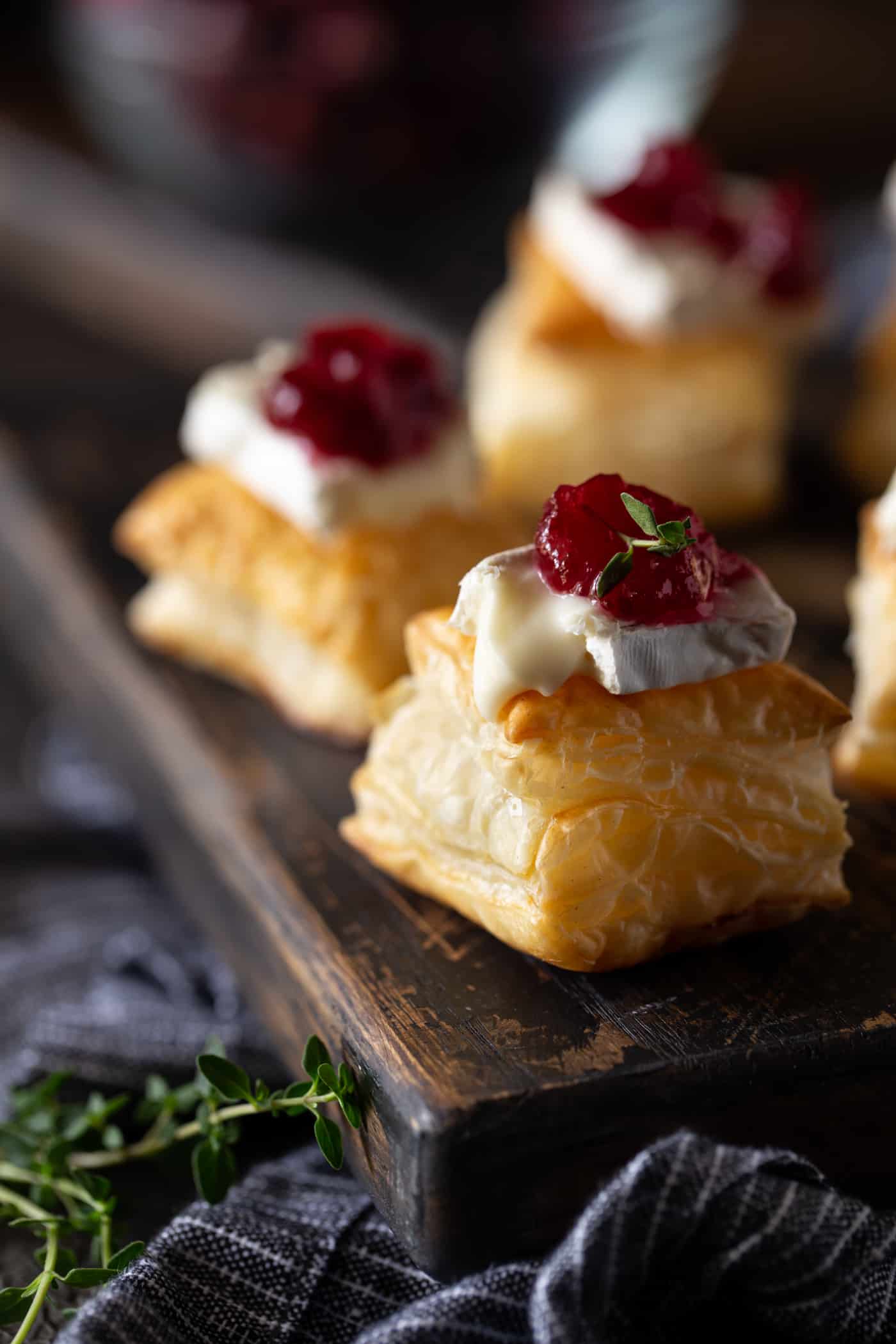 cranberry brie bite on a dark board with fresh thyme for garnish.
