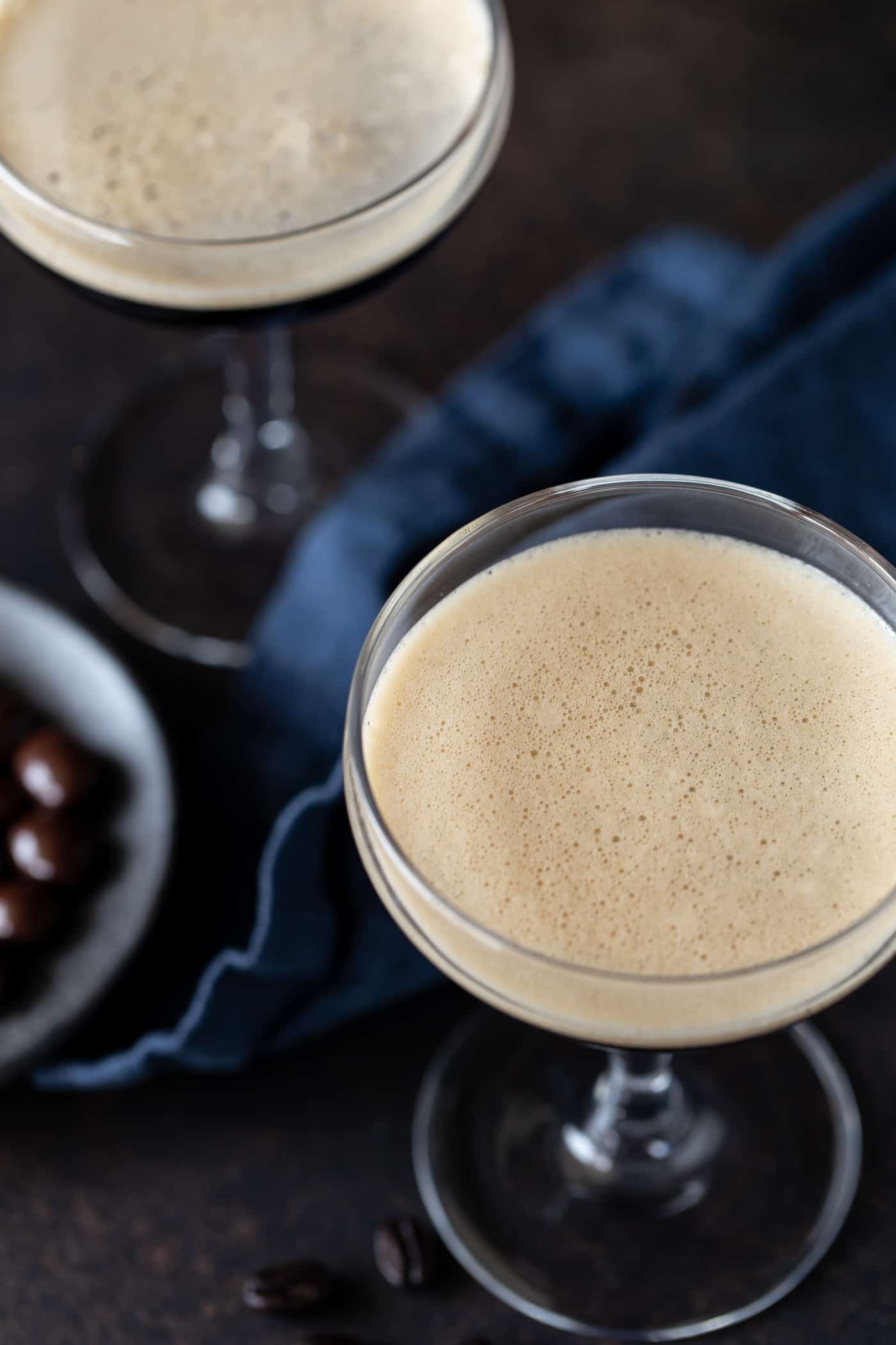 A martini on a table, with napkin and Garnish.