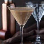 2 martini glasses on a table with a rose gold martini shaker.